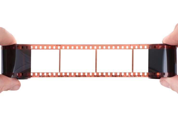 Película antigua con marco vacío en las manos sobre fondo blanco.