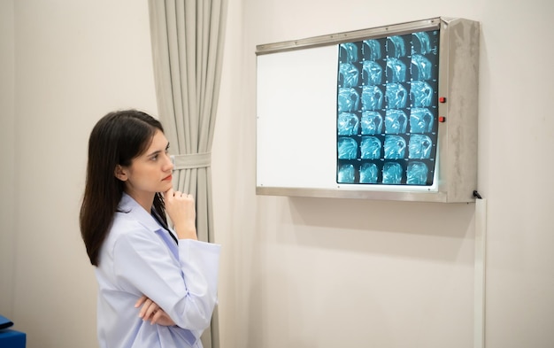 Película de rayos X del médico y del paciente en la sala de exámenes del hospital