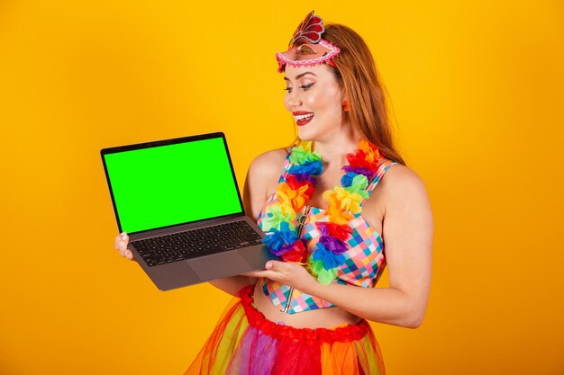 Pelirroja brasileña vestida de carnaval con un collar de flores alrededor del cuello sosteniendo un cuaderno