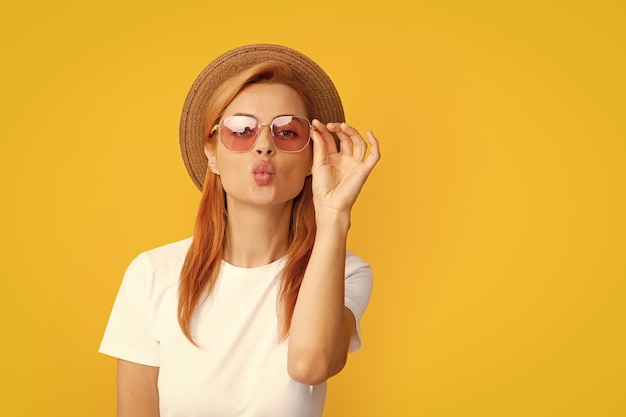 La pelirroja envía un beso al aire retrato de una joven hermosa con sombrero de paja y gafas de sol verano