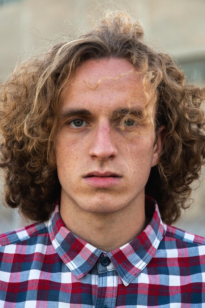 Pelirroja joven caucásico con cabello rizado vistiendo camisa a cuadros mirando a la cámara Retrato vertical