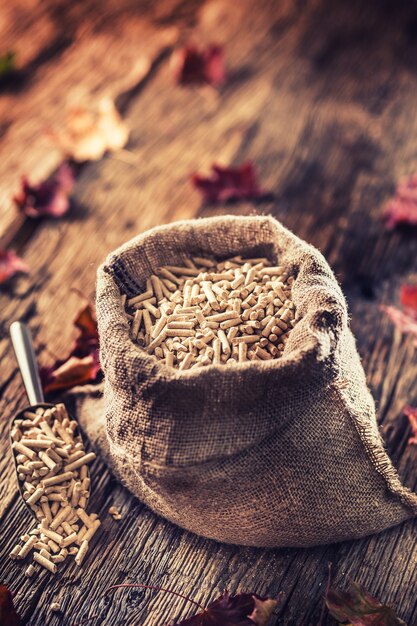 Pellets de madera prensada a partir de biomasa en saco viejo.