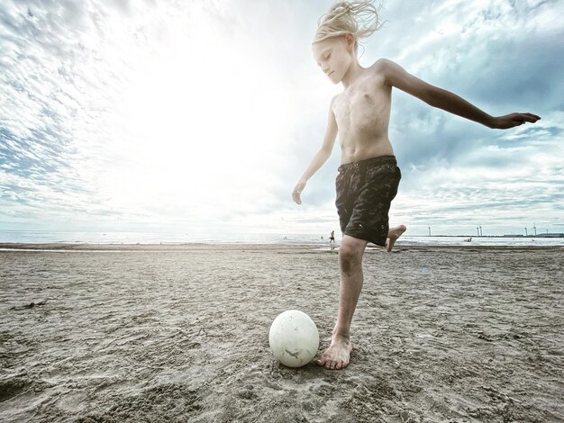 Foto pelo comprimento de uma bola de mulher na praia