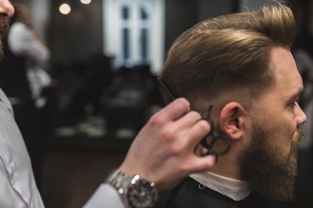 Pelo de corte de barbero de hombre barbudo