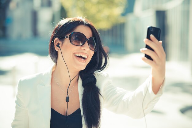 pelo largo y negro elegante mujer de negocios elegante con smartphone