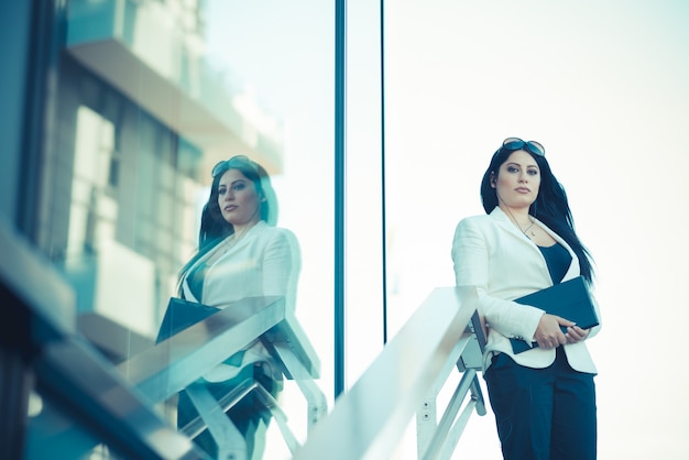 pelo largo y negro elegante mujer de negocios elegante con tableta