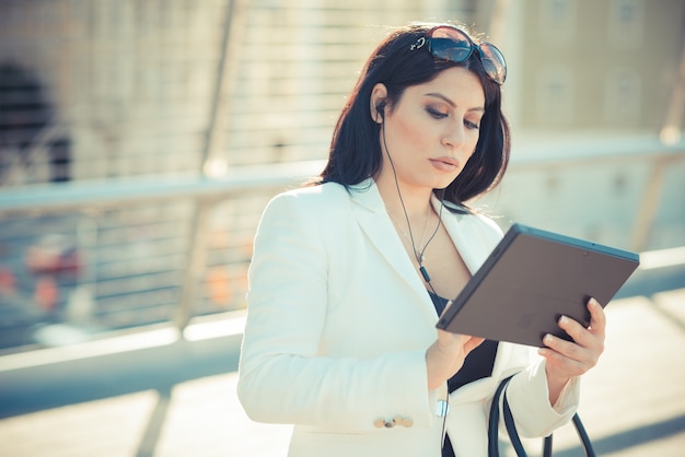 Pelo largo y negro elegante mujer de negocios elegante con tableta