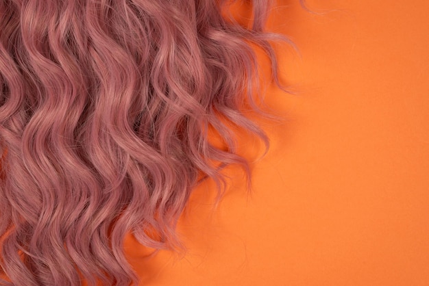 Pelo rosa de verano sobre fondo naranja