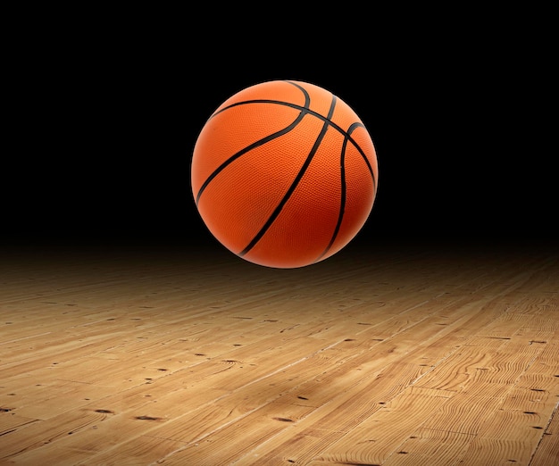 Una pelota de baloncesto con un fondo oscuro en el piso de un gimnasio de madera dura