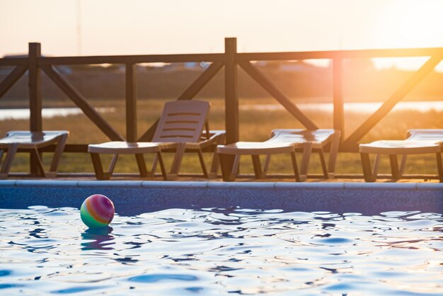 La pelota flota en la superficie del agua en la piscina bajo el sol de verano