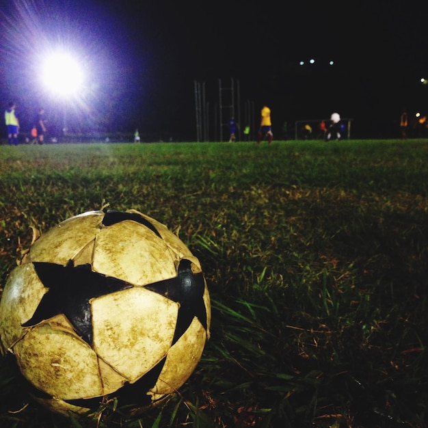 Foto la pelota de fútbol en el campo por la noche