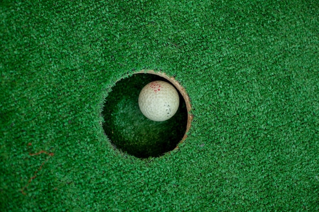 pelota de golf blanca cerca del hoyo la pelota de golf en el hoyo