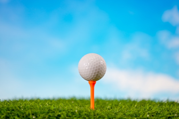 Pelota de golf en tee en campo de golf en cielo azul