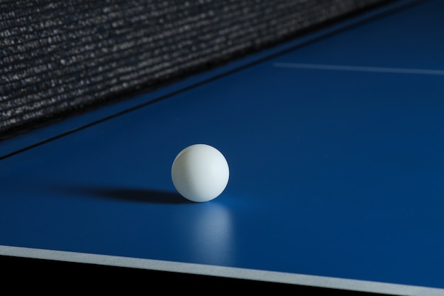 Pelota de ping pong en una mesa azul