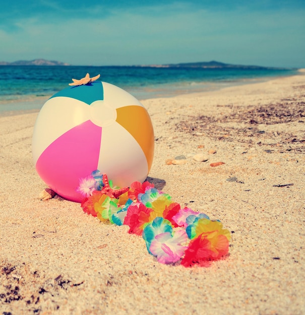 Pelota de playa y collar junto a una costa turquesa en Cerdeña