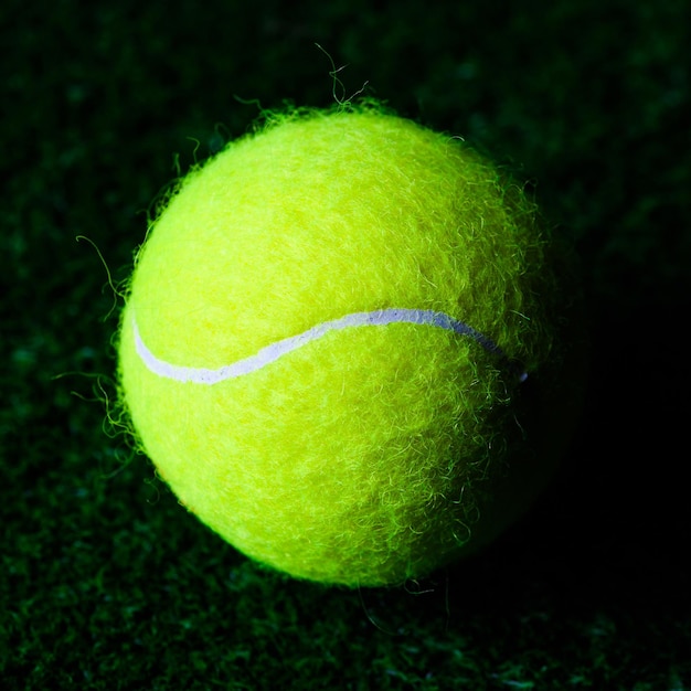 Pelota de tenis aislada en negro con iluminación espectacular