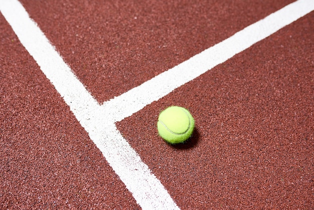 Foto pelota de tenis en el piso de la cancha