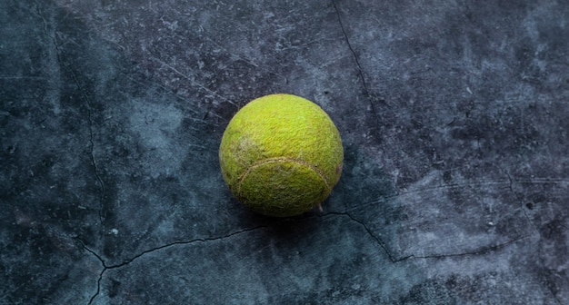 Foto pelota de tenis verde vieja y polvorienta