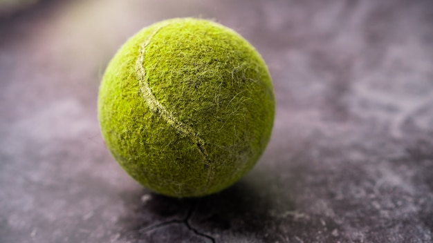 Foto pelota de tenis verde vieja y polvorienta