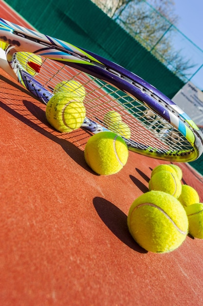 Pelotas de tenis y raquetas en la cancha de césped