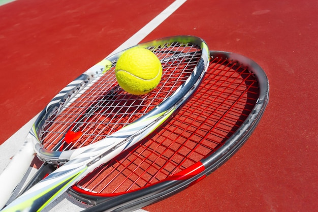 Foto pelotas de tenis y raquetas en la cancha de césped