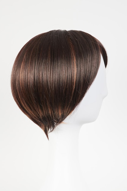 Peluca morena oscura de aspecto natural en cabeza de maniquí blanco Cabello castaño corto en el soporte de peluca de plástico aislado en vista lateral de fondo blanco