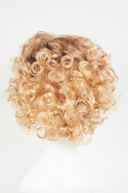 Peluca rubia de aspecto natural en cabeza de maniquí blanca corte de pelo corto en el soporte de peluca de plástico aislado en fondo blanco vista trasera