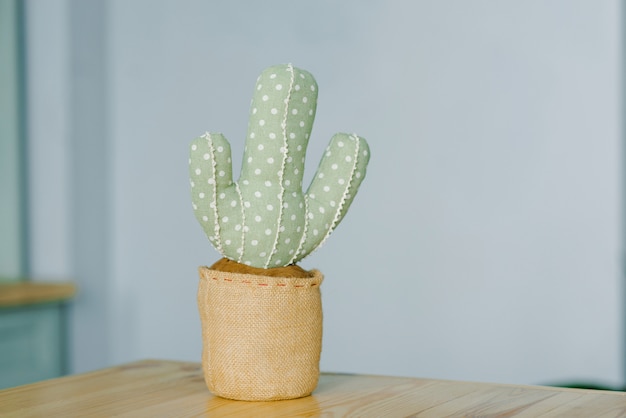 Peluche de cactus en un estante de madera