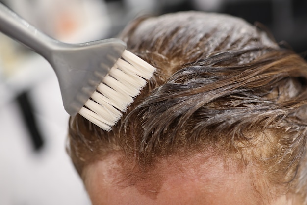 Peluquería aplicando tinte para el cabello con cepillo