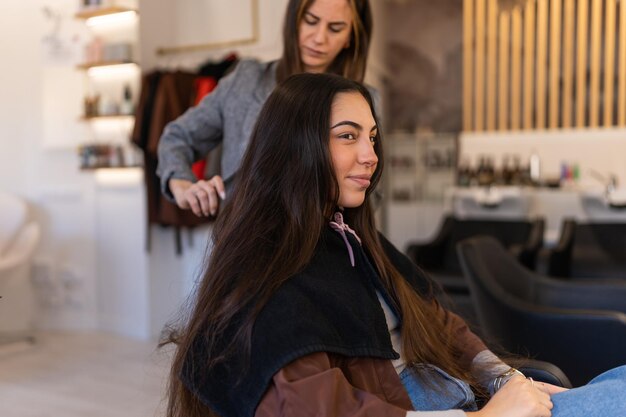 Peluquería concentrada peinando el cabello del cliente en el salón