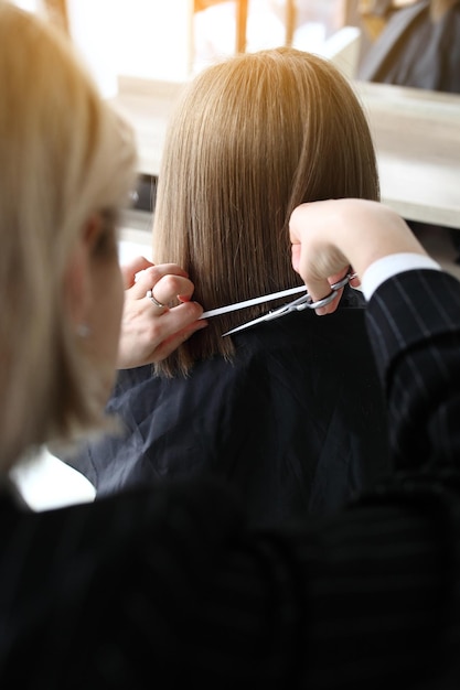 Peluquería cortando el cabello en primer plano del salón