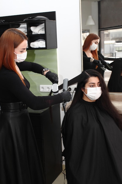 Peluquería con mascarilla médica trabaja en el salón.