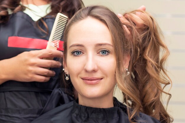 Peluquería de mujeres, salón de belleza. Cerca de una peluquería haciendo un peinado.