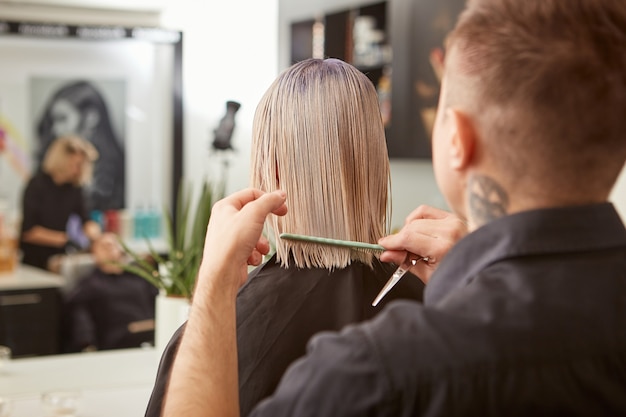 Foto peluquería peinando el cabello de la mujer en el salón de belleza