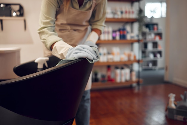 Peluquería para pequeñas empresas y sillas de limpieza para mujeres con equipo en un moderno salón de belleza en la ciudad Limpiadora o niña lavando muebles en una peluquería con productos de higiene y desinfección