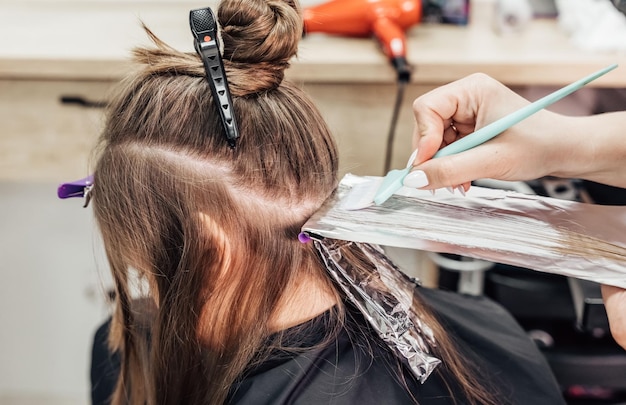 Peluquería profesional muriendo el cabello del cliente en el primer plano del salón de belleza