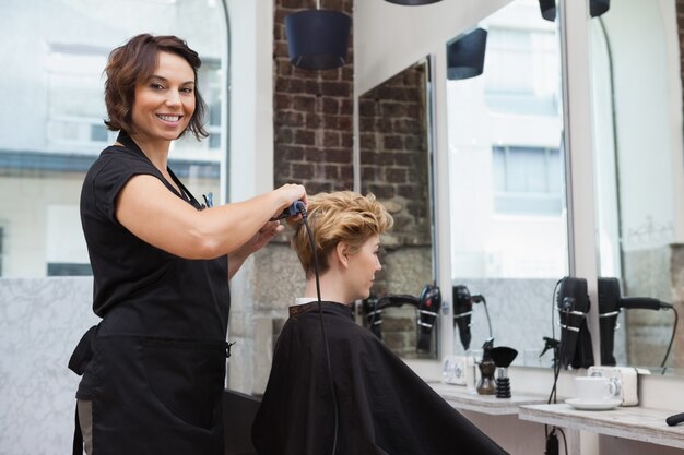 Foto peluquería secando el cabello de un cliente