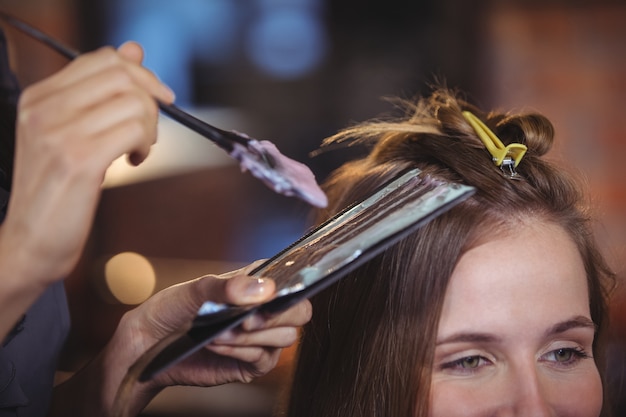 Peluquería teñiendo el cabello de su cliente