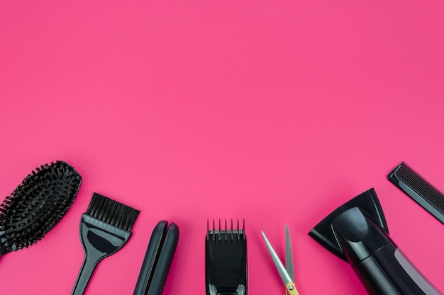 Peluquería con varios accesorios sobre un fondo rosa con espacio para copiar