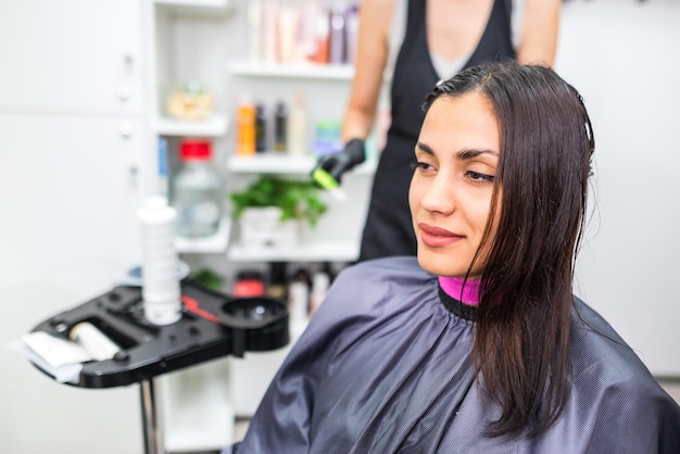 El peluquero aplica queratina líquida profesional al cabello del cliente Una niña fortalece el cabello con queratina en un salón de belleza Cuidado del cabello