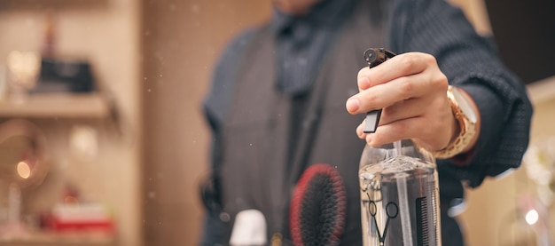 Peluquero, barbero en un delantal sobre un fondo claro