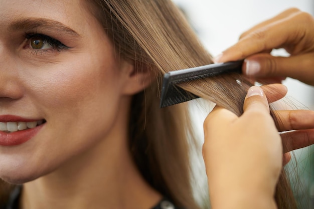 Peluquero cepillando el cabello del cliente