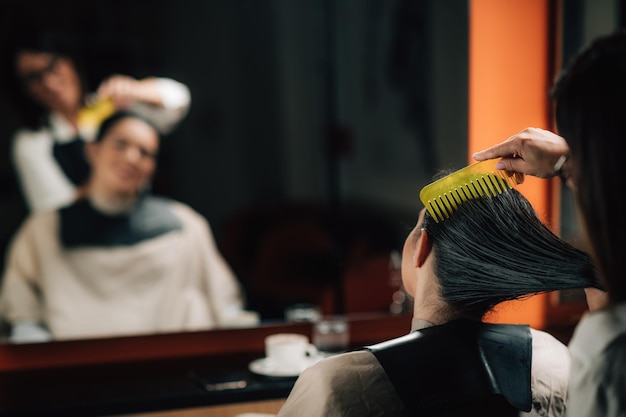 El peluquero cepillando el cabello húmedo de las mujeres