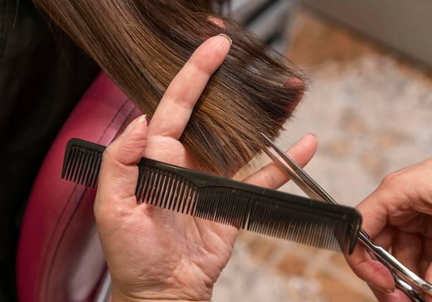 Foto peluquero cuidando el cabello de un cliente en el salón