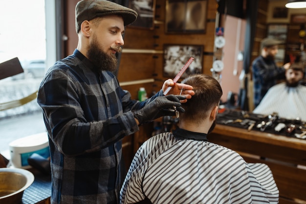 El peluquero hace un corte de pelo al cliente, peluquería