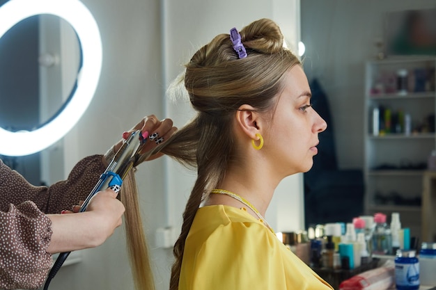 Peluquero hace un peinado en un salón de belleza