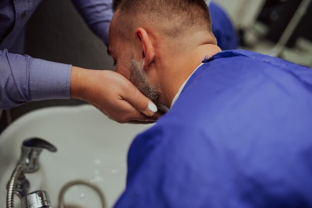 Peluquero lavando ositos de clientes en una barbería. Enfoque selectivo. foto de alta calidad