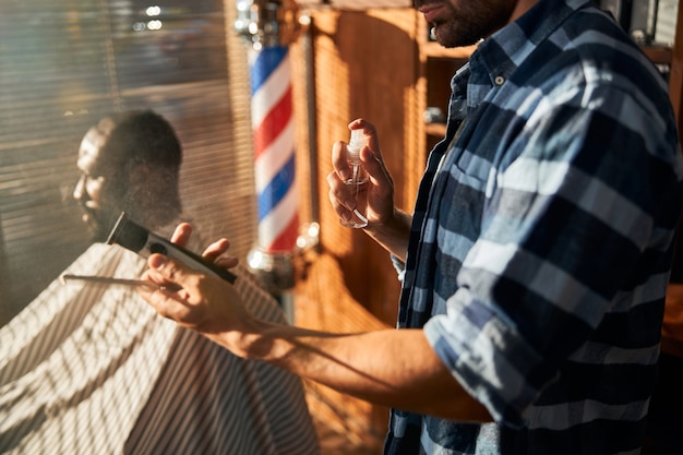 Foto peluquero masculino desinfectar herramientas de peluquería antes del corte de pelo