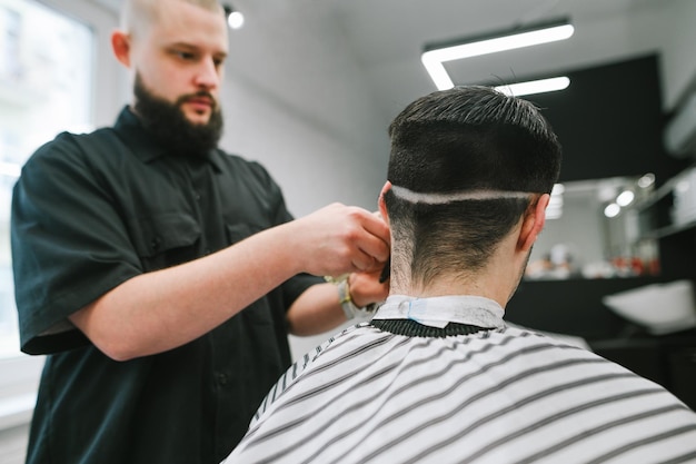 peluquero masculino hace un corte de pelo con un recortador Copiar espacio