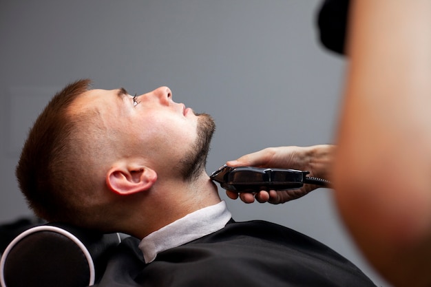 Peluquero recortando la barba de un cliente